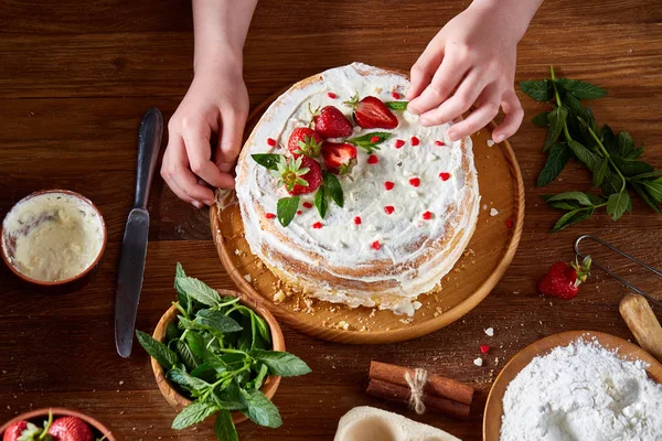 Kızlar el çilek pasta, yakın çekim, selctive odaklanmak, dikey koyarak üstten görünüm.