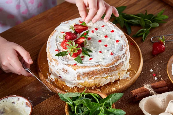 Kızlar el çilek pasta, yakın çekim, selctive odaklanmak, dikey koyarak üstten görünüm.