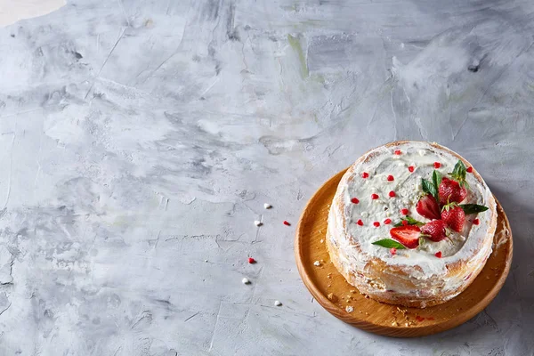 Çilek ve beyaz dokulu arka planda, seçici odak nane yaprakları ile süslenmiş krem şanti ile tart