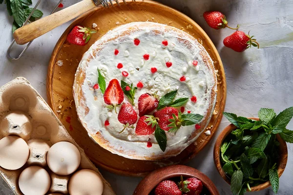 Çilekli tart beyaz arka plan üzerinde düz yatıyordu organik maddeler tarafından çevrili ekşi krem şanti ile kaplı.