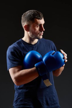 Düşük anahtar stüdyo portre yakışıklı kaslı dövüşçülerin korku koyu arka plan bulanık boks için hazırlanıyor