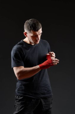 Düşük anahtar stüdyo portre yakışıklı kaslı dövüşçülerin korku koyu arka plan bulanık boks için hazırlanıyor