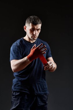 Düşük anahtar stüdyo portre yakışıklı kaslı dövüşçülerin korku koyu arka plan bulanık boks için hazırlanıyor