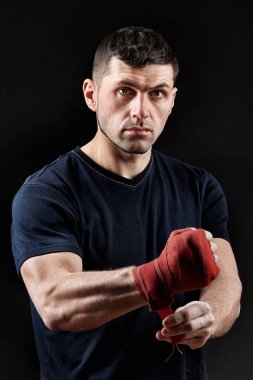 Düşük anahtar stüdyo portre yakışıklı kaslı dövüşçülerin korku koyu arka plan bulanık boks için hazırlanıyor