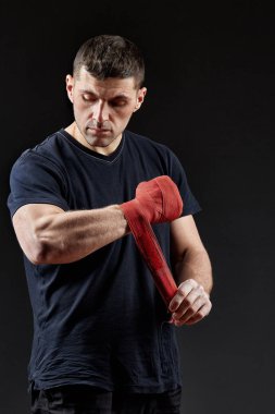 Düşük anahtar stüdyo portre yakışıklı kaslı dövüşçülerin korku koyu arka plan bulanık boks için hazırlanıyor