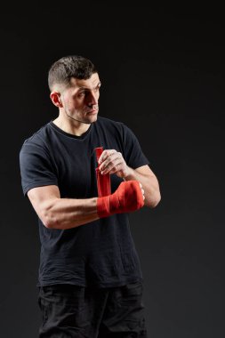 Düşük anahtar stüdyo portre yakışıklı kaslı dövüşçülerin korku koyu arka plan bulanık boks için hazırlanıyor