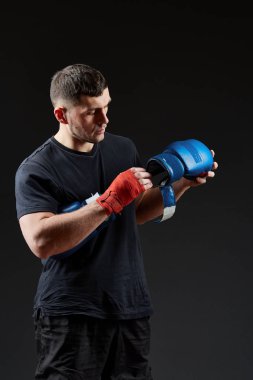 Düşük anahtar stüdyo portre yakışıklı kaslı dövüşçülerin korku koyu arka plan bulanık boks için hazırlanıyor