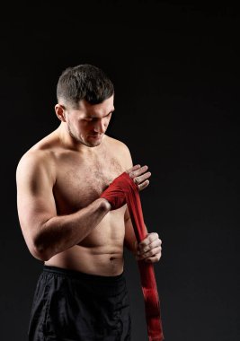 Düşük anahtar stüdyo portre yakışıklı kaslı Fighter boks koyu arka plan bulanık üzerinde pratik