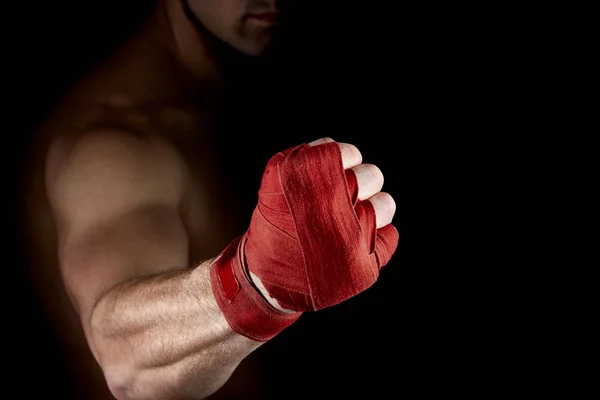 Un vendaje rojo boxeador en su mano aislado sobre fondo oscuro borroso, primer plano . — Foto de Stock