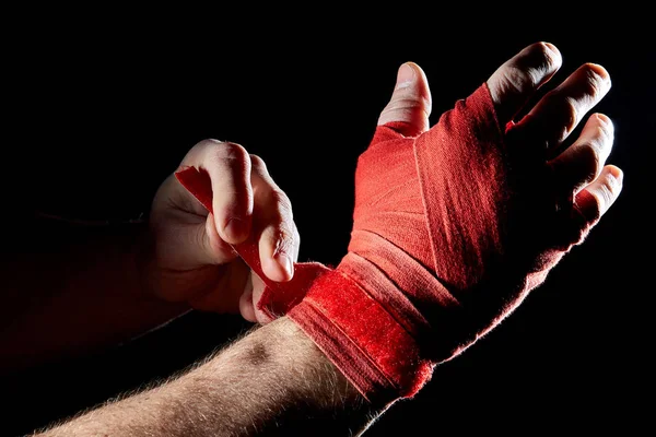 Elini bulanık koyu arka plan üzerinde izole bir boksörler kırmızı bandaj yakın çekim. — Stok fotoğraf