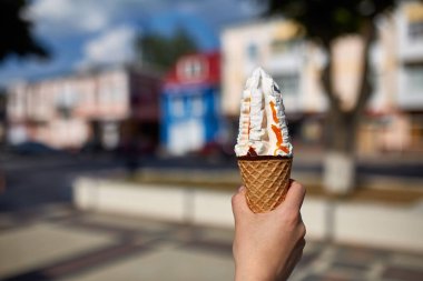 Bir ilk kişi görünümü, kız bir dondurma sığ derinlik-in tarla onun elinde olan yol boyunca yürüyüş.