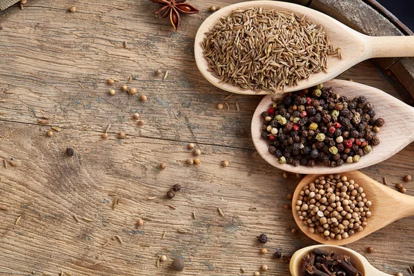 Renkli aromatik eski ahşap masa, yakın çekim, düz yemek pişirmek için çeşitli baharatlar lay, seçici odak, dikey.