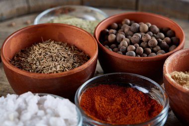 Ahşap varil, yakın çekim, seçici odak, dikey üst Seramik kase içinde baharatlar.