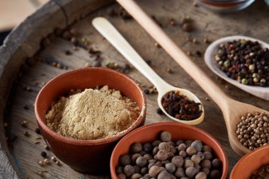 Tahta kaşık ve kase ve biraz tuz bir eski ahşap varil, üstten görünüm, yakın çekim, seçici odak içinde çeşitli baharatlar.