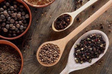 Tahta kaşık ve kase ve biraz tuz bir eski ahşap varil, üstten görünüm, yakın çekim, seçici odak içinde çeşitli baharatlar.