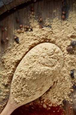 Paprica ve karabiber dolu bir tahta kaşıklar üstten görünüm ahşap varil arka plan, seçici odak üzerinde.