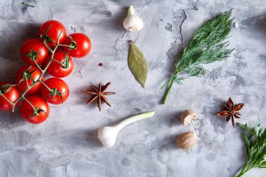 Kiraz domates ve çeşitli baharatlar beyaz dokulu arka plan, düz üzerinde yatıyordu, yakın çekim, seçici odak.