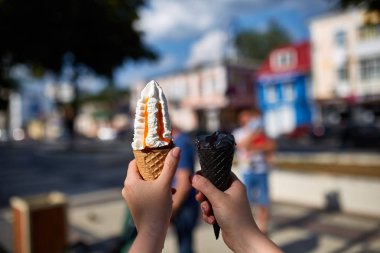 Bir ilk kişi görünümü, kız bir dondurma sığ derinlik-in tarla onun elinde olan yol boyunca yürüyüş.