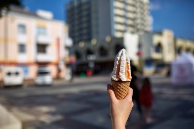 Bir ilk kişi görünümü, kız bir dondurma sığ derinlik-in tarla onun elinde olan yol boyunca yürüyüş.