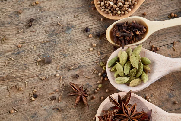 Renkli aromatik eski ahşap masa, yakın çekim, düz yemek pişirmek için çeşitli baharatlar lay, seçici odak, dikey.