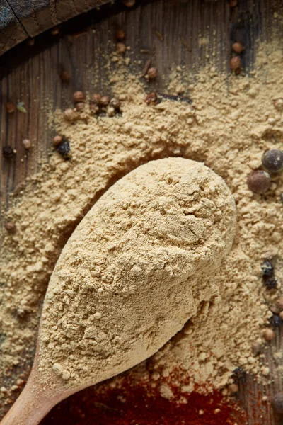 Bovenaanzicht van een houten lepels vol met paprica en zwarte peper op houten vat achtergrond, selectieve aandacht. — Stockfoto