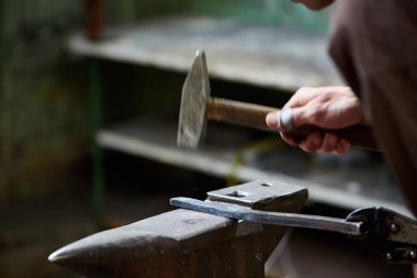 Onun forge, seçici odak üstünde metal bir parça işleme bir demirci elleri Close-up.