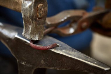 Onun forge, seçici odak üstünde metal bir parça işleme bir demirci elleri Close-up.