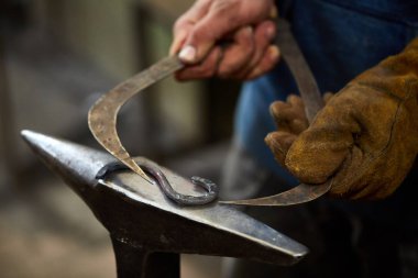 Onun forge, seçici odak üstünde metal bir parça işleme bir demirci elleri Close-up.