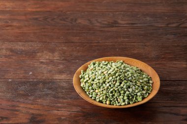 Bir kase ve plaka rustik ahşap arka plan, yakın çekim, üstten görünüm seçici odak üzerinde Besleyici yeşil bezelye.