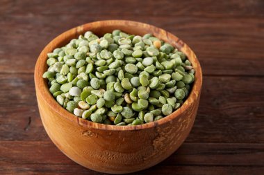 Bir kase ve plaka rustik ahşap arka plan, yakın çekim, üstten görünüm seçici odak üzerinde Besleyici yeşil bezelye.