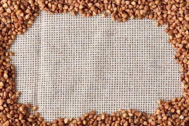 Karabuğday kabuğu çıkarılmış tane çuval bezi arka plan, üstten görünüm, yakın çekim, seçici odak, sığ derinlik-in tarla, dikey.