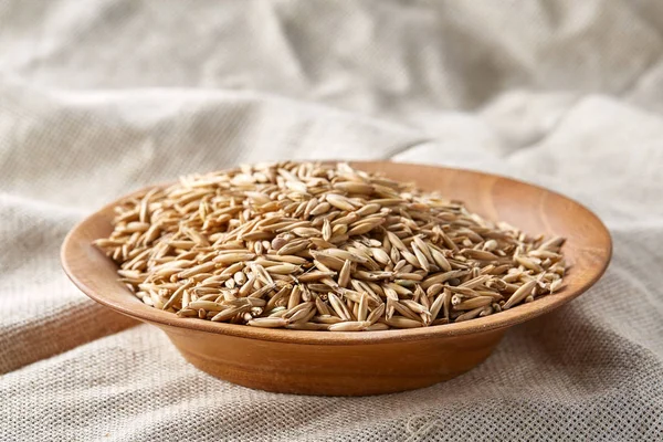 Yulaf kabuğu çıkarılmış tane veya yulaf ani artış ahşap plaka eski ahşap arka plan, kopya alanı, üstten görünüm seçici odak üzerinde