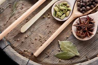 Renkli aromatik eski ahşap masa, yakın çekim, düz yemek pişirmek için çeşitli baharatlar yatıyordu, seçici odak.