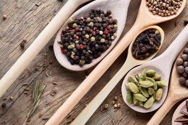 Renkli aromatik eski ahşap masa, yakın çekim, düz yemek pişirmek için çeşitli baharatlar yatıyordu, seçici odak.