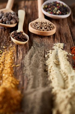 Tahta kaşıklar ile baharat vintage arka planda, perspektif, yakın çekim, seçici odak azalan sıra