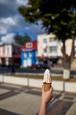 Bir ilk kişi görünümü, kız bir dondurma sığ derinlik-in tarla onun elinde olan yol boyunca yürüyüş.