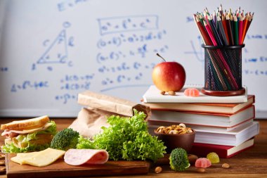 Geri okul kavramı, okul malzemeleri, bisküvi ve beslenme çantası beyaz yazı tahtası, seçici odak, yakın çekim için.