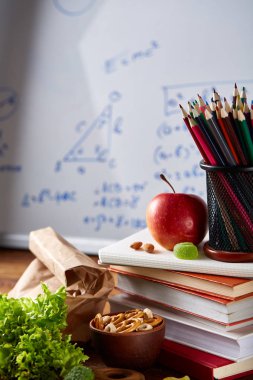 Geri okul kavramı, okul malzemeleri, bisküvi ve beslenme çantası beyaz yazı tahtası, seçici odak, yakın çekim için.