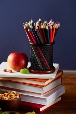 Yeşil salata ve konteyner ve okul malzemeleri, ahşap masa, seçici odak üzerinde sebze ile lezzetli öğle yemeği.