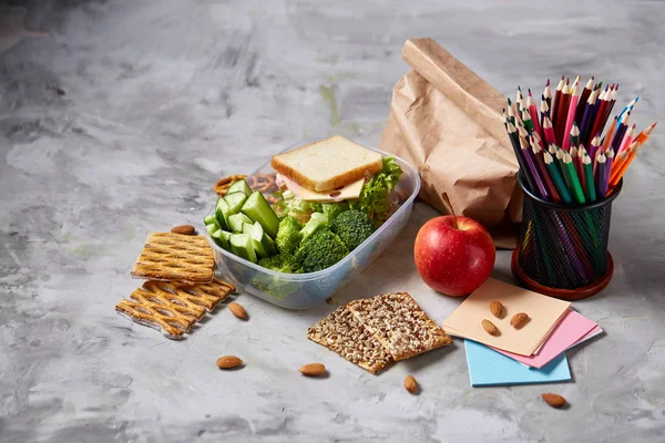 Back to School concept, school supplies, biscuits and lunchbox on white desk, selective focus, close-up. — Stock Photo, Image