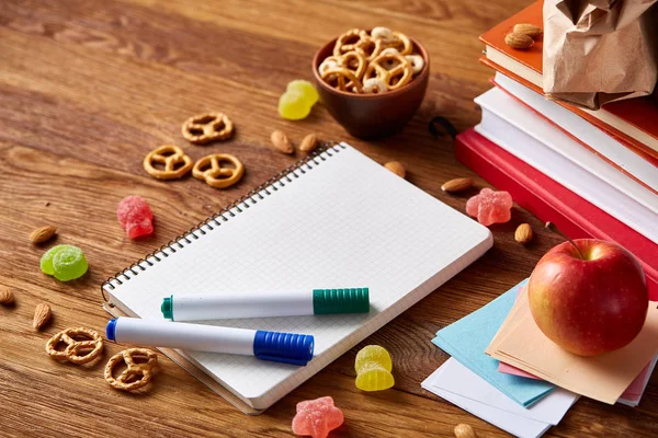 Yeşil salata ve konteyner ve okul malzemeleri, ahşap masa, seçici odak üzerinde sebze ile lezzetli öğle yemeği.