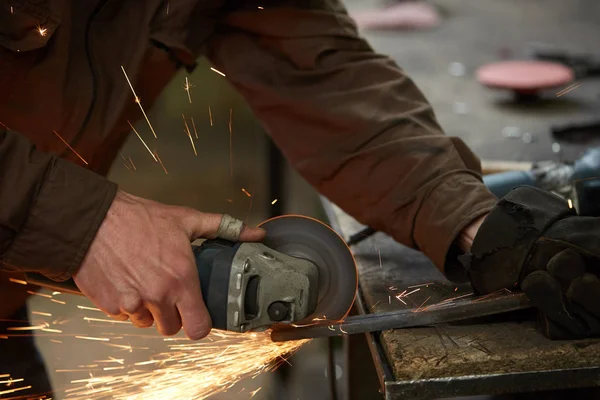 Close-up de um ferreiro mãos manipulando uma peça de metal acima de sua forja, foco seletivo . — Fotografia de Stock