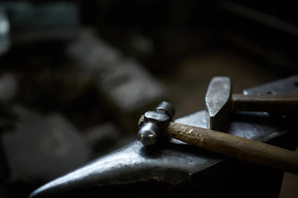 Close-up van een smeden handen manipuleren van een metalen stuk boven zijn smederij, selectieve aandacht. — Stockfoto