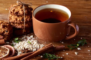 Bir fincan sıcak çay, kurabiye ve dekorasyon ahşap arka plan, seçici odak üzerinde bir oturum ile Noel kavramı