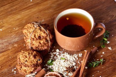 Bir fincan sıcak çay, kurabiye ve dekorasyon ahşap arka plan, seçici odak üzerinde bir oturum ile Noel kavramı