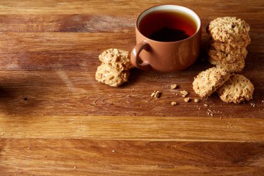 Porselen fincan çay ve tatlı kurabiye ahşap arka plan, üstten görünüm, seçici odak