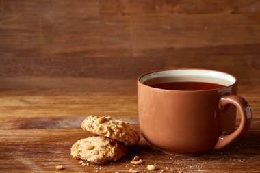 Porselen fincan çay ve tatlı kurabiye ahşap arka plan, üstten görünüm, seçici odak