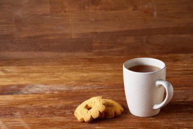 Beyaz porselen kupa çay ve tatlı kurabiye ahşap arka plan, üstten görünüm, seçici odak