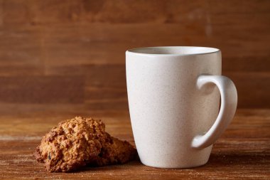 Beyaz porselen kupa çay ve tatlı kurabiye ahşap arka plan, üstten görünüm, seçici odak