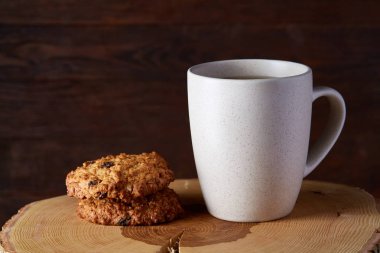 Beyaz porselen kupa çay ve tatlı kurabiye ahşap arka plan, üstten görünüm, seçici odak